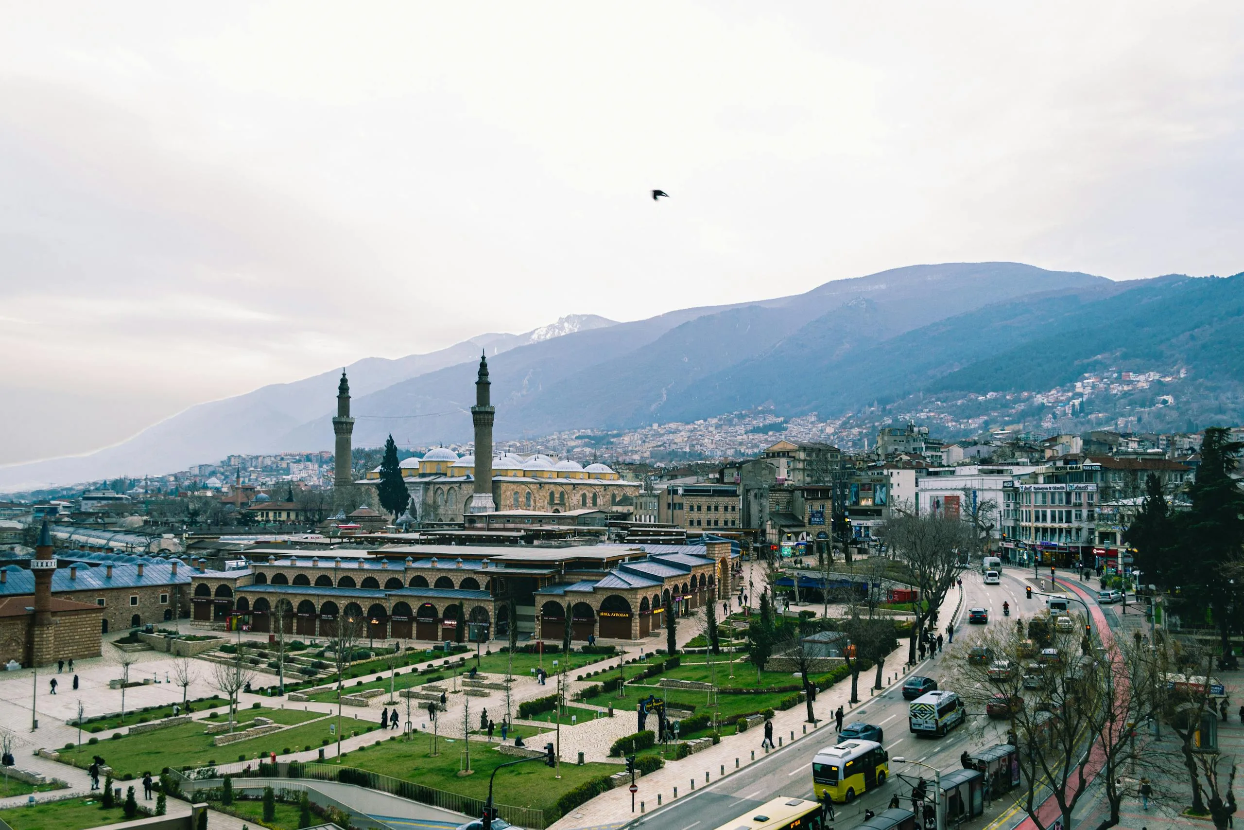 Stafford Affiliates Travel - A scenic view of Bursa, featuring the historic Ulu Cami mosque set against a backdrop of majestic mountains.