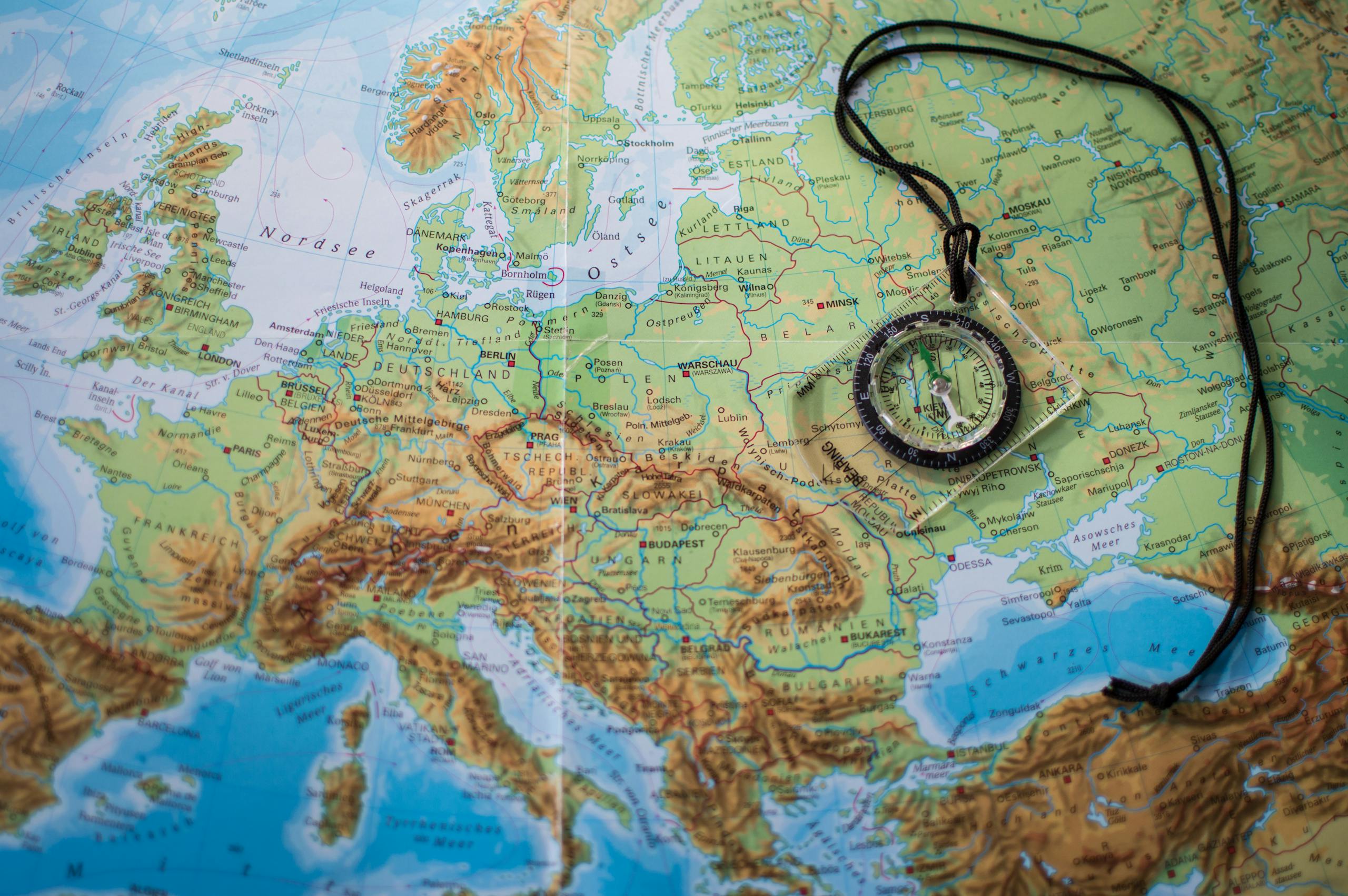 Stafford Affiliates Travel - A compass placed on a detailed map of Europe showcasing travel and exploration themes.