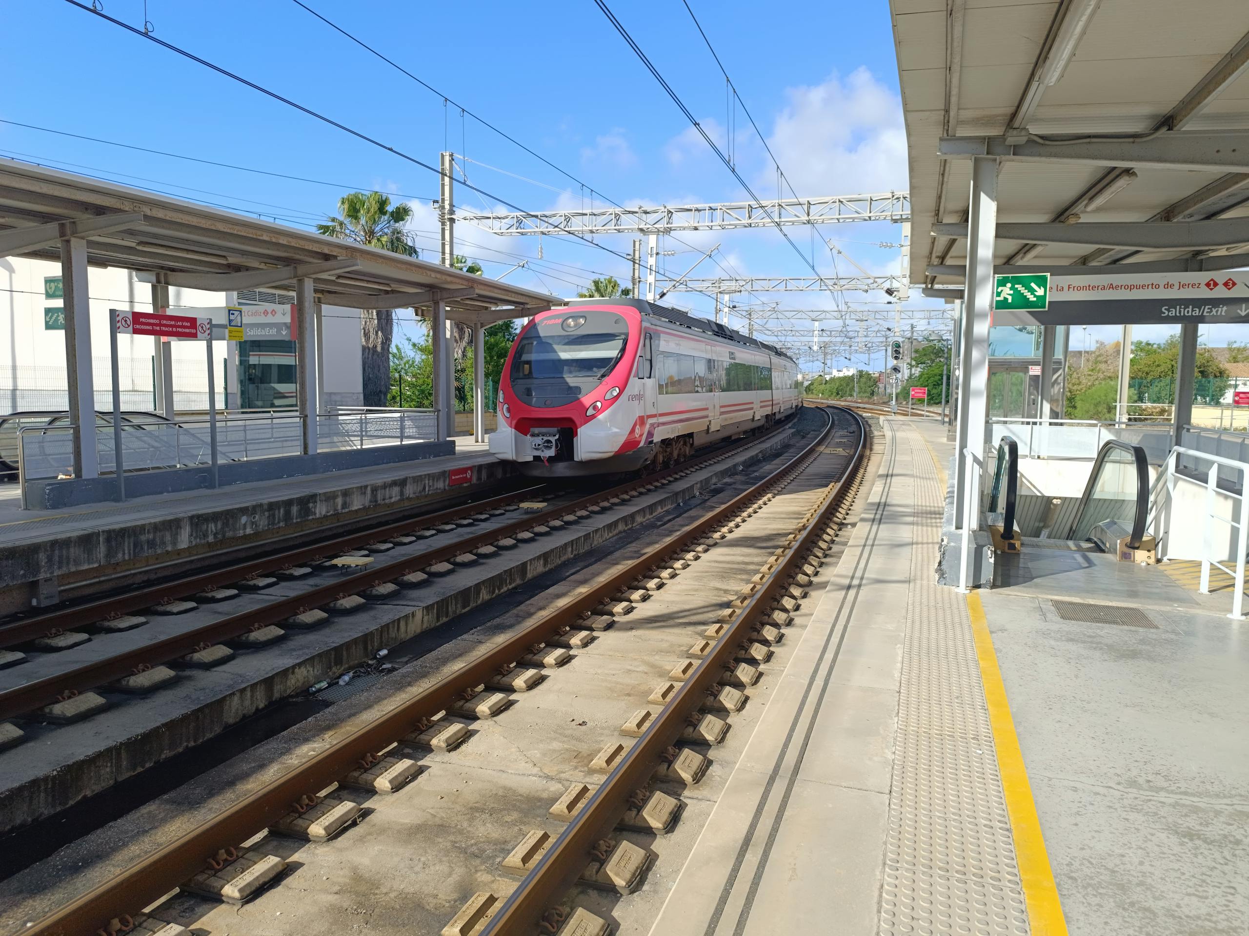 Stafford Affiliates Travel - A modern train approaches a railway station on a sunny day in Andalusia, Spain.