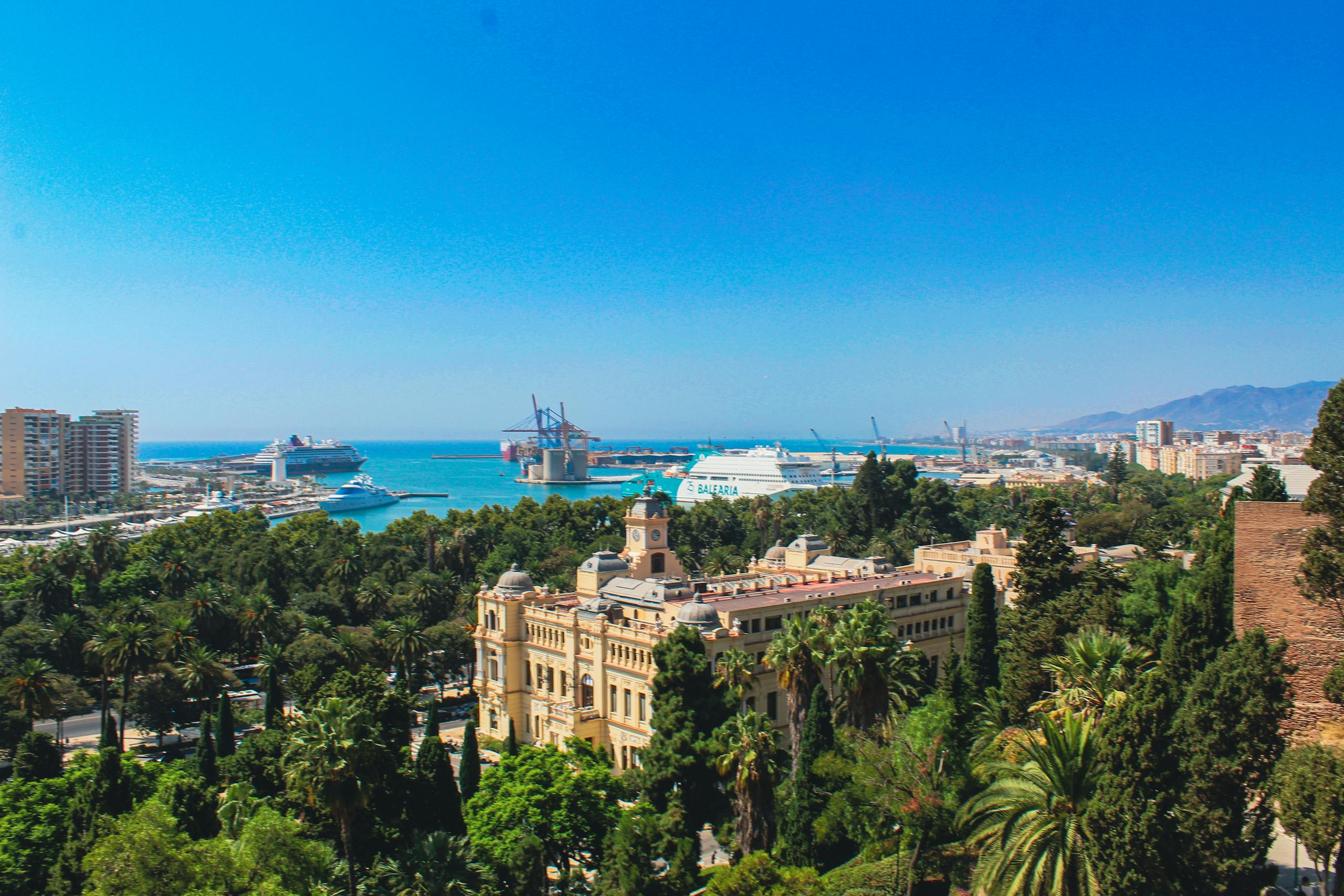 Stafford Affiliates Travel - Breathtaking aerial view of Málaga, Spain featuring the bustling port and lush greenery.