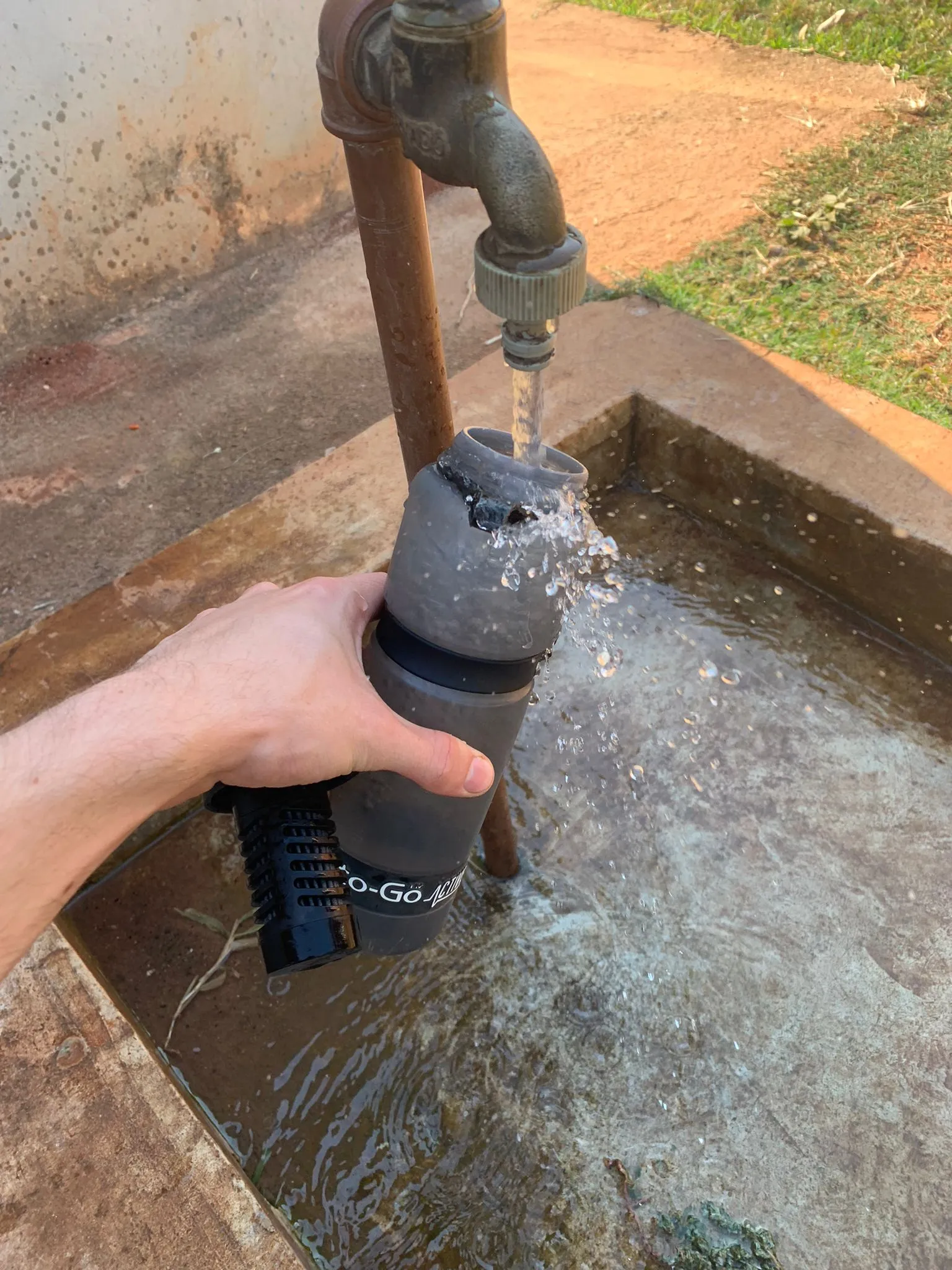 Hand filling a Water-to-Go filter bottle from an outdoor tap while travelling. Stafford Affiliates Travel