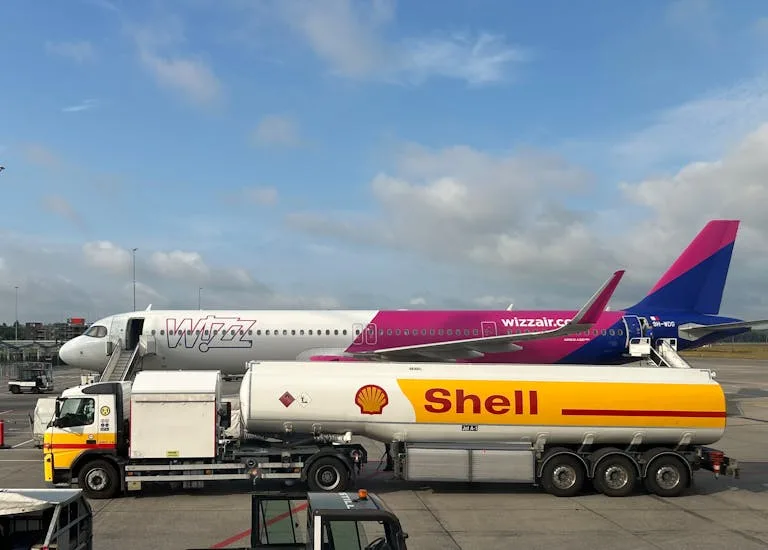 A plane being refuelled by a Shell fuel truck on a sunny day at the airport - Stafford Affiliates Travel