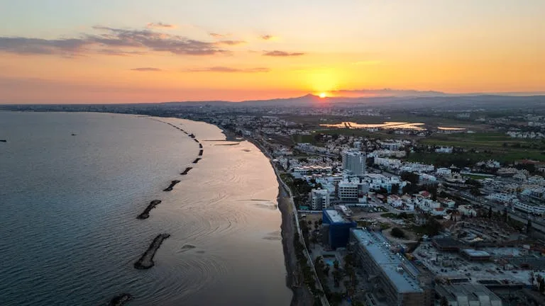Aerial view of Limassol's coastline during sunset, showcasing the vibrant city and serene sea - Stafford Affiliates Travel