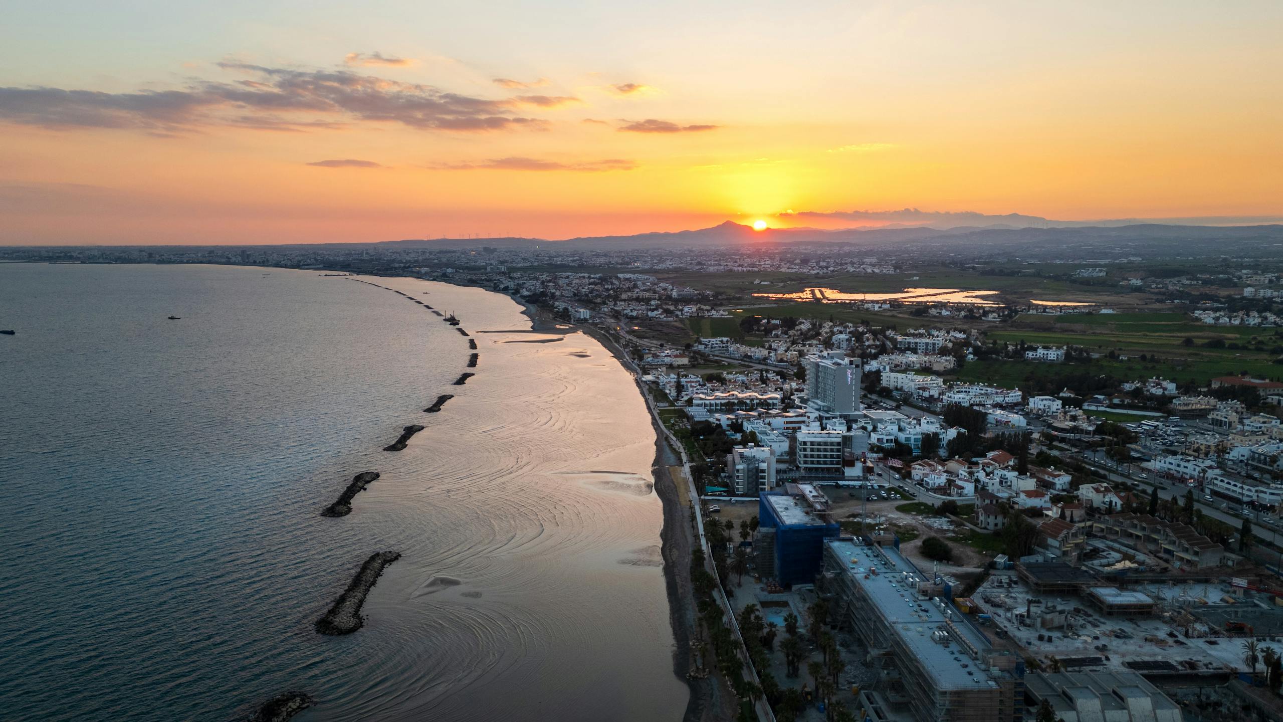 Aerial view of Limassol's coastline during sunset, showcasing the vibrant city and serene sea - Stafford Affiliates Travel
