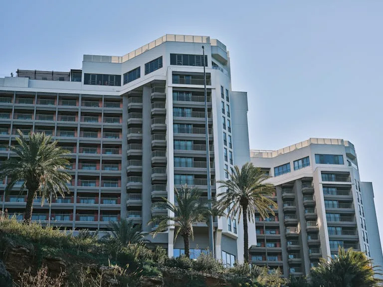 Contemporary hotel building exterior in Antalya, Turkey, featuring modern architecture and palm trees - Stafford Affiliate Travel