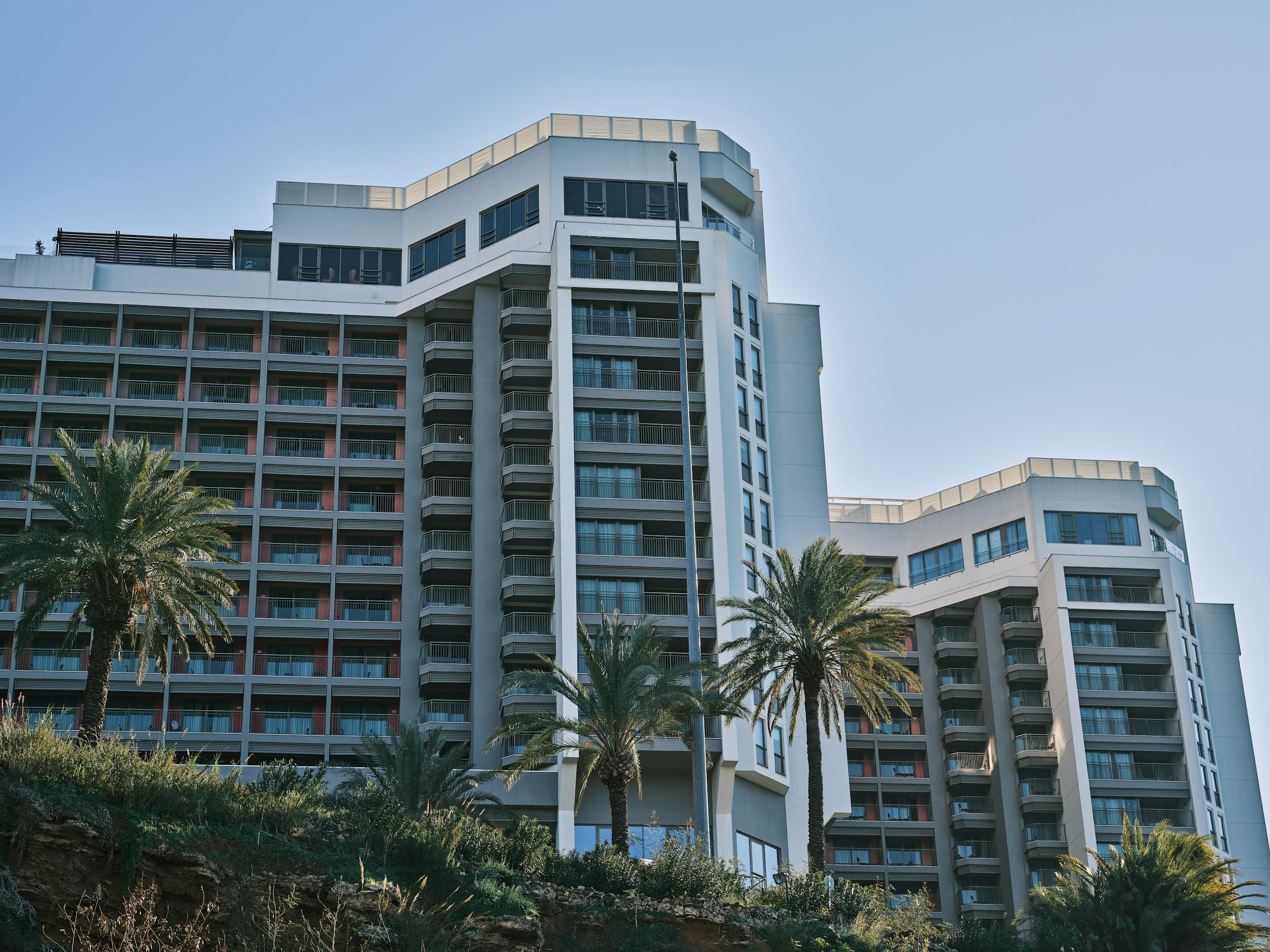 Contemporary hotel building exterior in Antalya, Turkey, featuring modern architecture and palm trees - Stafford Affiliate Travel