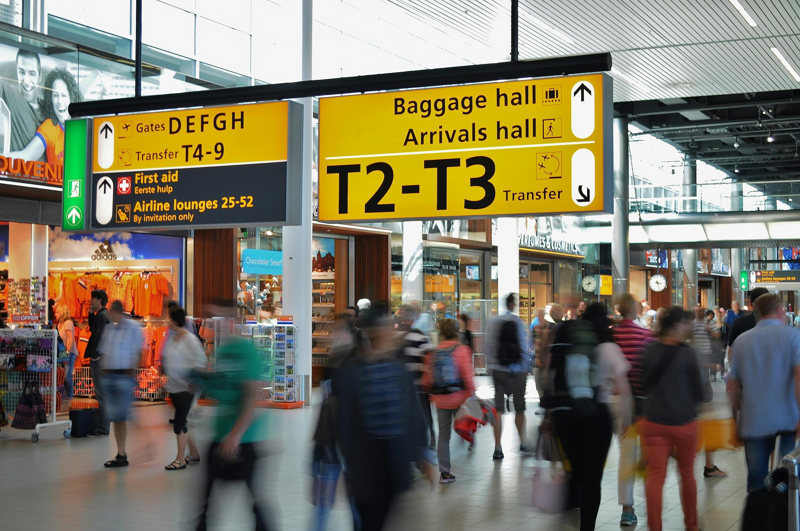 Crowded airport with motion blur and clear signage indicating baggage and arrival halls - Stafford Affiliate Travel