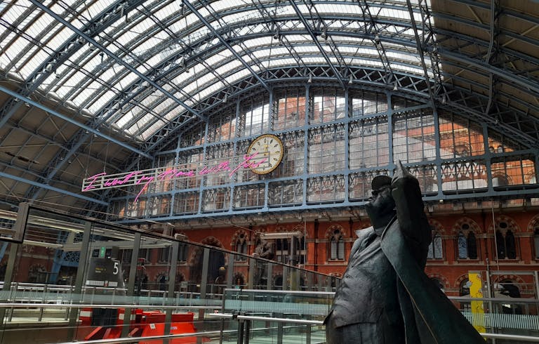 Interior view of St Pancras International Station with clock and statue. Stafford Affiliates Travel