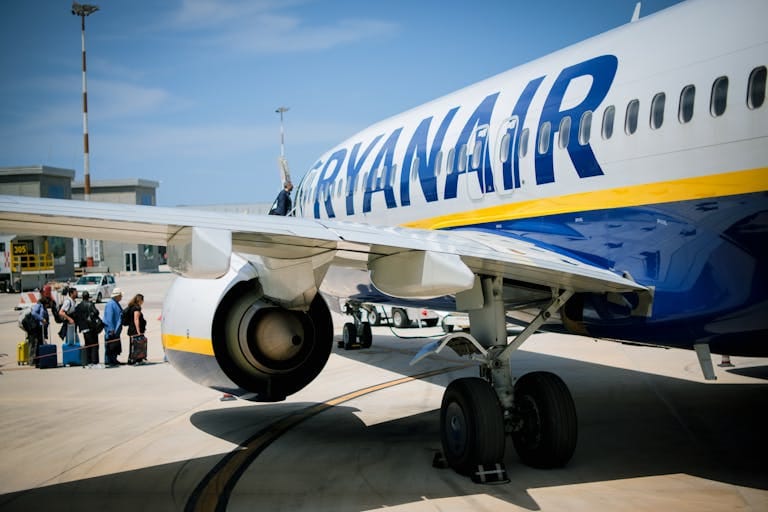 Passengers boarding a Ryanair plane on a sunny day at a Sicilian airport - Stafford Affiliates Travel