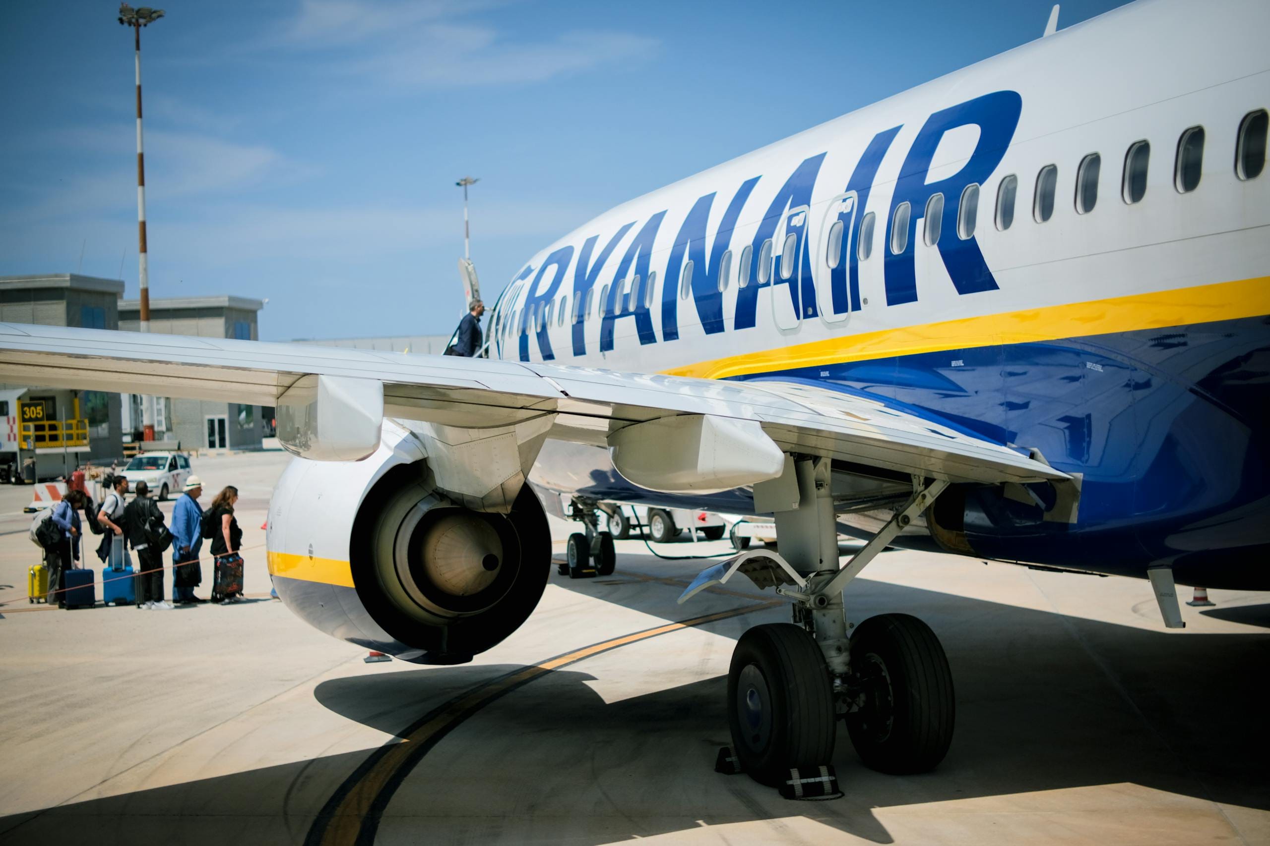 Passengers boarding a Ryanair plane on a sunny day at a Sicilian airport - Stafford Affiliates Travel