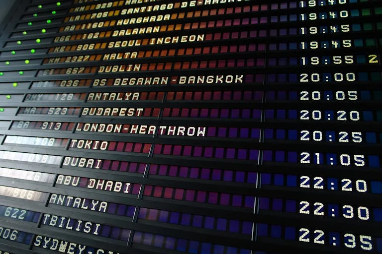 Stafford Affiliates Travel - Retro flip-style airport departure board showing international flight destinations and times.