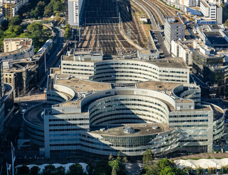 Stunning aerial shot of Paris cityscape and Gare Montparnasse railway station capturing urban architecture and railway tracks. Stafford Affiliates Travel