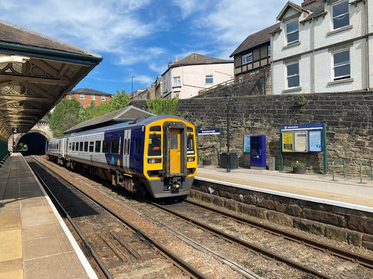 Train arriving at Knaresborough station in England under a clear sky - Stafford Affiliates Travel