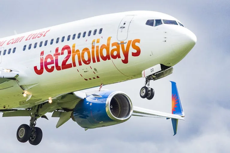 Up-close view of a Jet2 Holidays airplane landing with landing gear deployed - Stafford Affiliate Travel