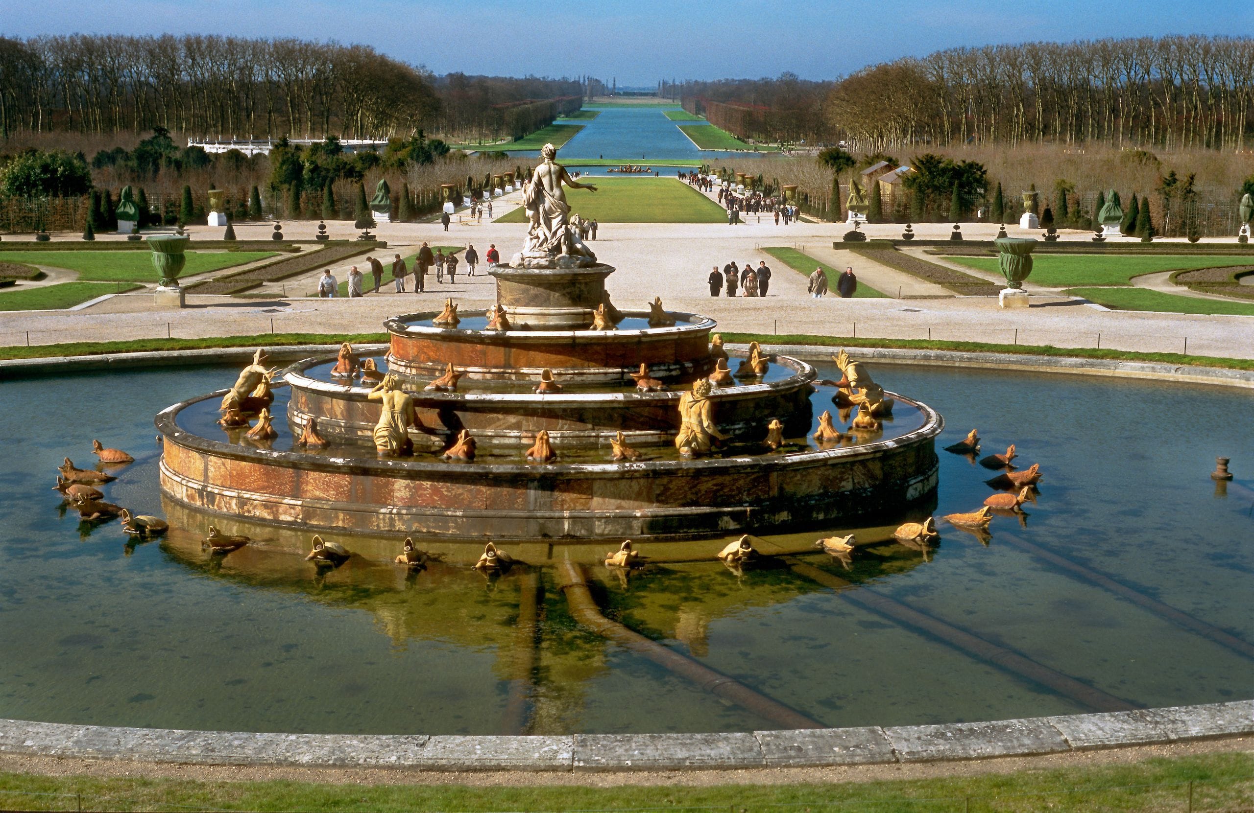 Classic fountain in the Gardens of Versailles surrounded by lush greenery and pathways - Stafford Affiliates Travel.