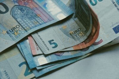 Detailed close-up of various Euro banknotes on a white surface, perfect for finance-related content - Stafford Affiliates Travel