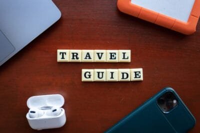 Flat lay of travel guide concept with smartphone, laptop, and headphones - Stafford Affiliates Travel