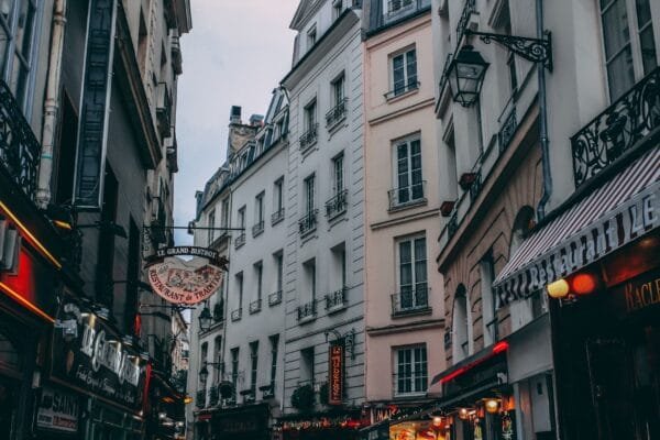 Quaint street in Paris showcasing classic French architecture and bustling shops.