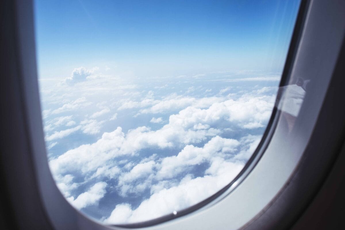 Breathtaking view of clouds and blue sky through an airplane window during flight.