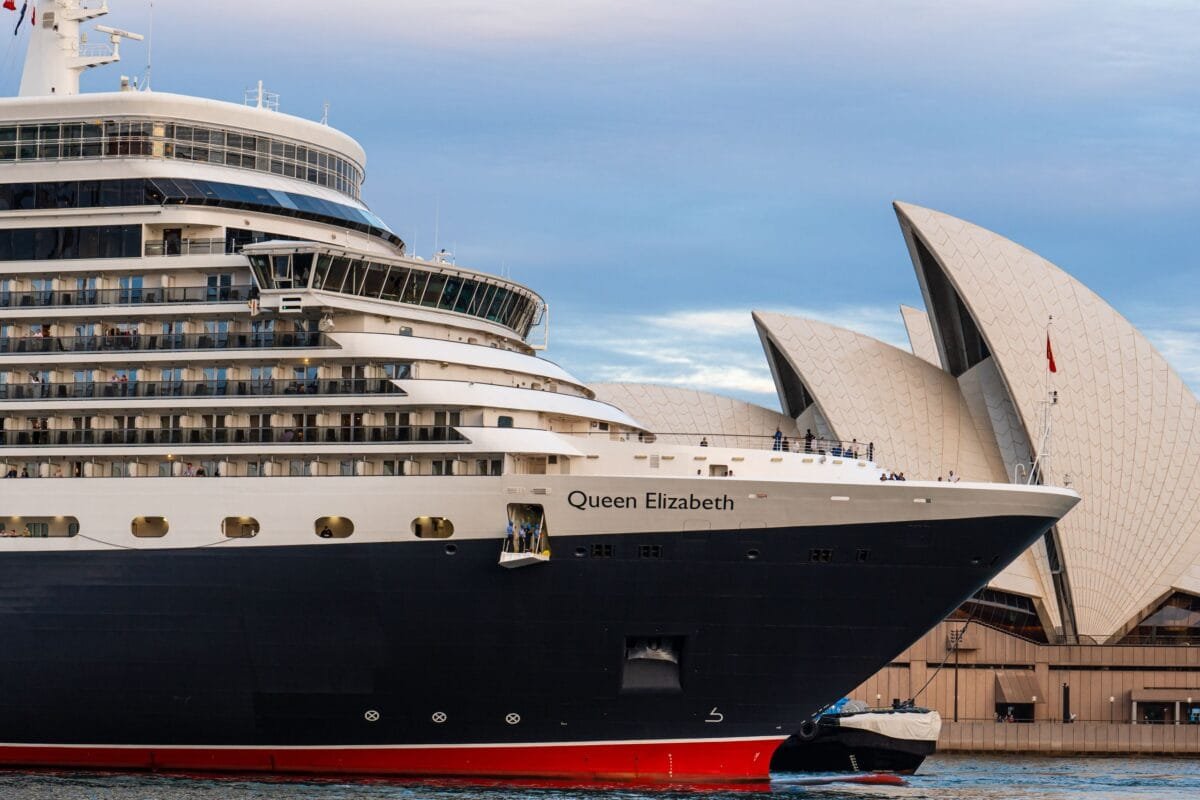 Queen Elizabeth cruise ship docked near Sydney Opera House, Australia at daytime.