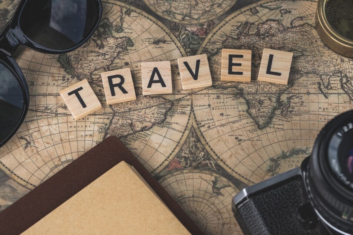 Vintage map with travel essentials like camera and sunglasses arranged in a flat lay, perfect for adventure themes. - Stafford Affiliates Travel